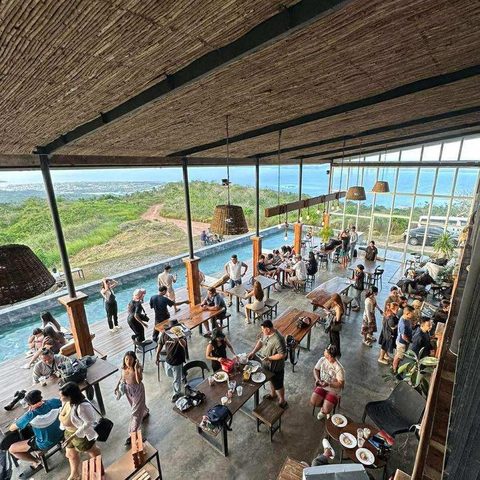 Guests sharing a meal in the open-air pavilion overlooking the bay
