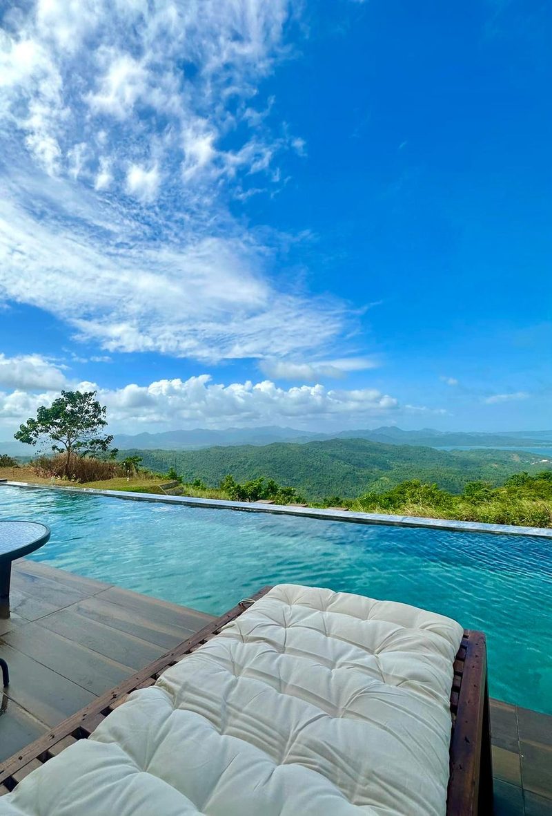 The infinity pool at Valle Justina meeting the horizon, with the mountains and bay of Masbate beyond