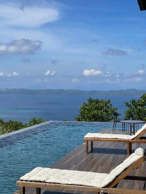 The pool and sun loungers at midday, looking out over Masbate Bay